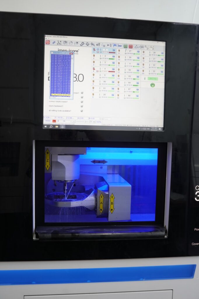 The imes-icore CORiTEC 350i PRO milling machine at Khai Nguyen Dental Lab, control screen above and milling chamber below